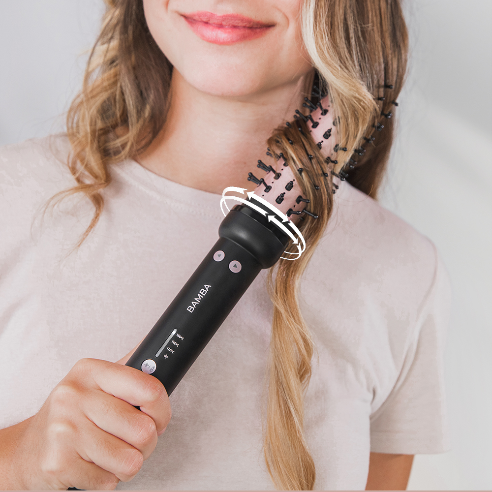 Mujer moldeando cabello rubio con un cepillo de aire caliente Bamba.
