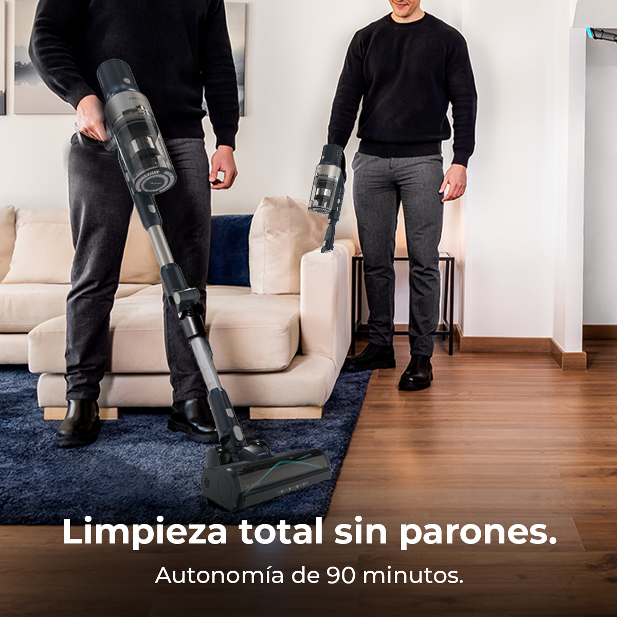 Un hombre aspira una alfombra azul con una aspiradora escoba sin cable.