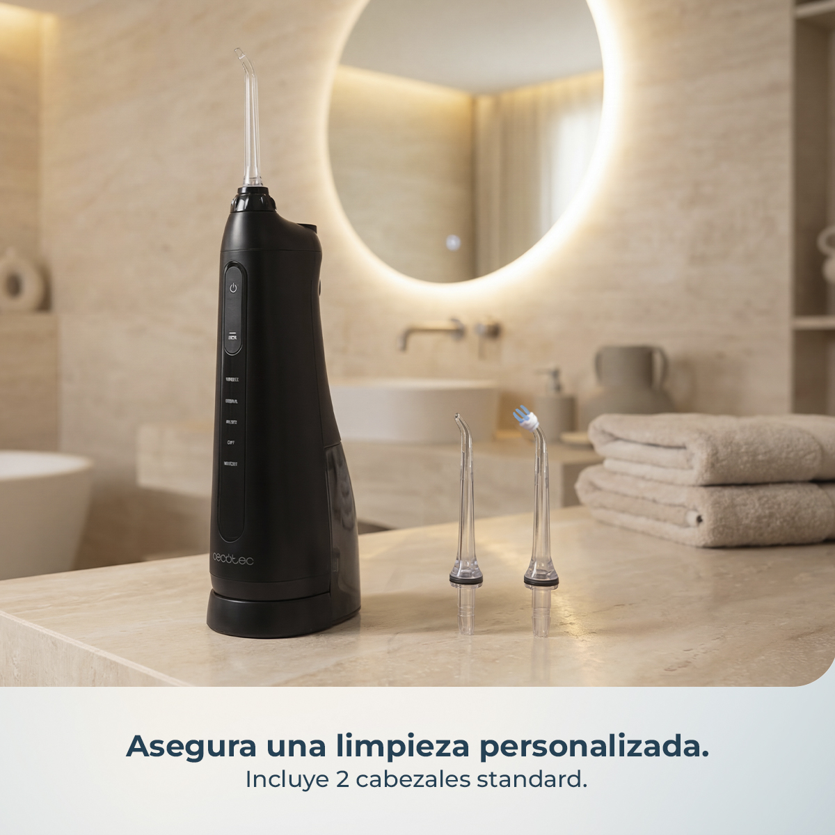 Irrigador bucal negro con dos boquillas de repuesto en un tocador de baño.