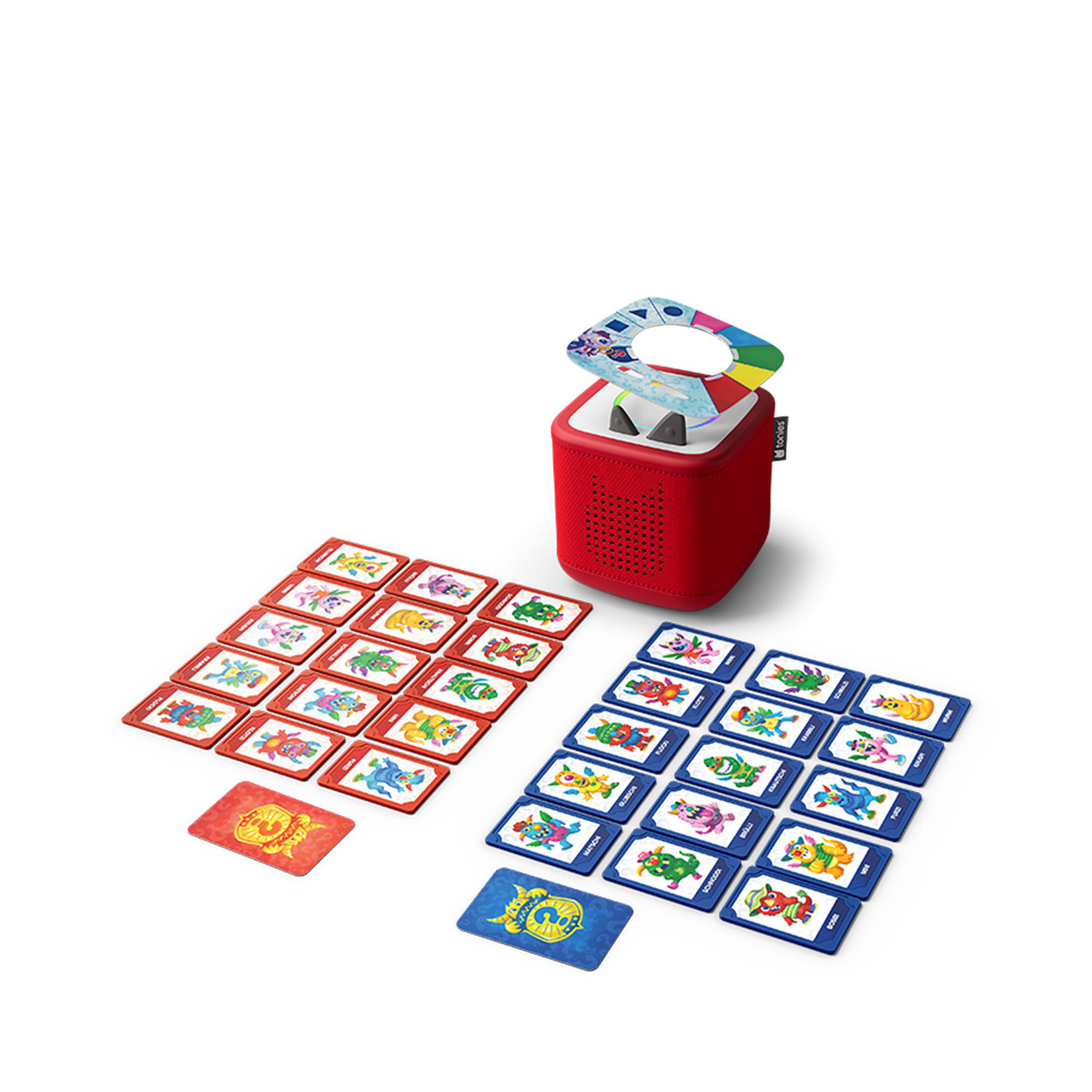 Ein roter Toniebox-Lautsprecher liegt neben roten und blauen Karten mit Cartoon-Monstern auf einem weißen Boden.