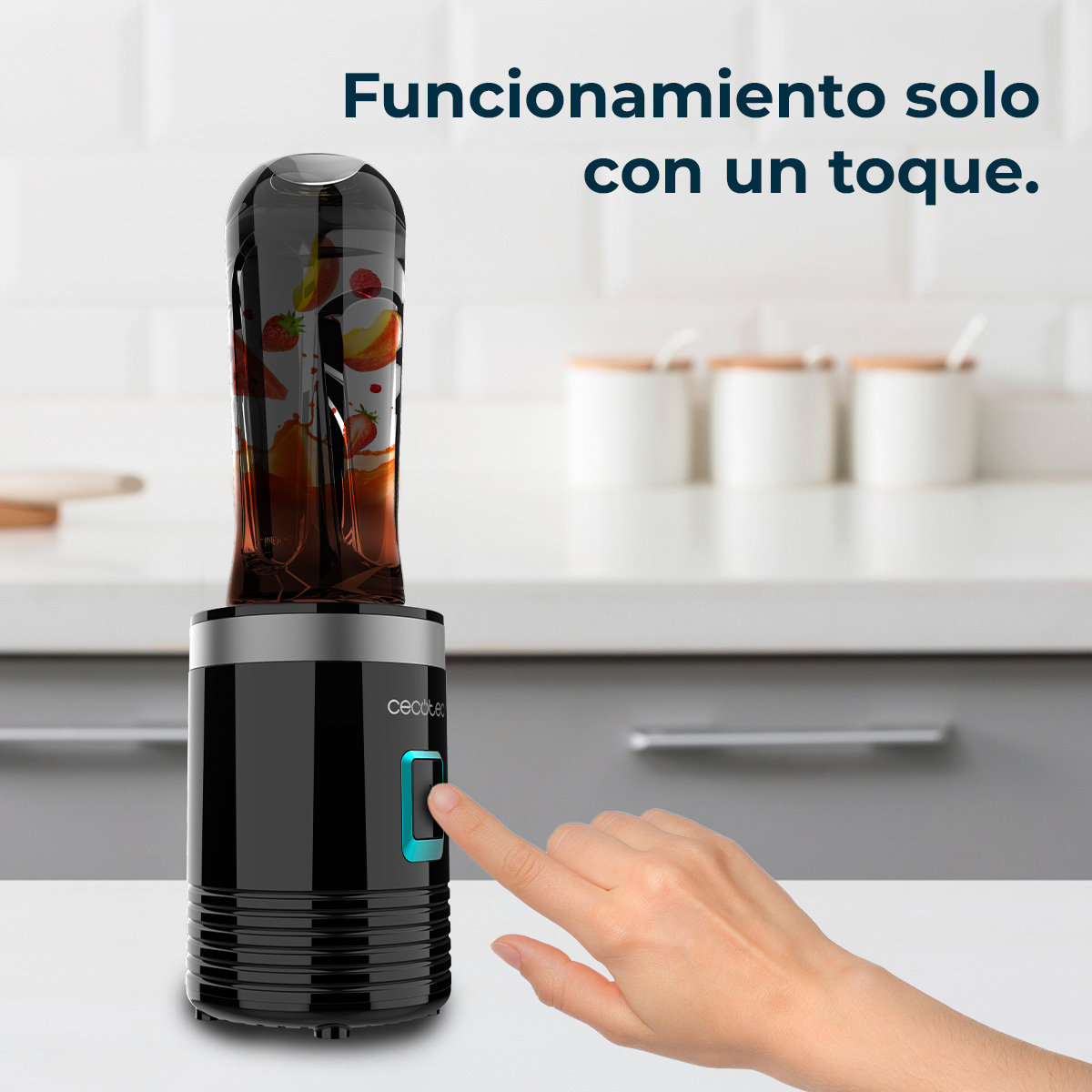 Una mano presiona el botón de inicio de una licuadora negra en una encimera de cocina clara con texto al fondo.