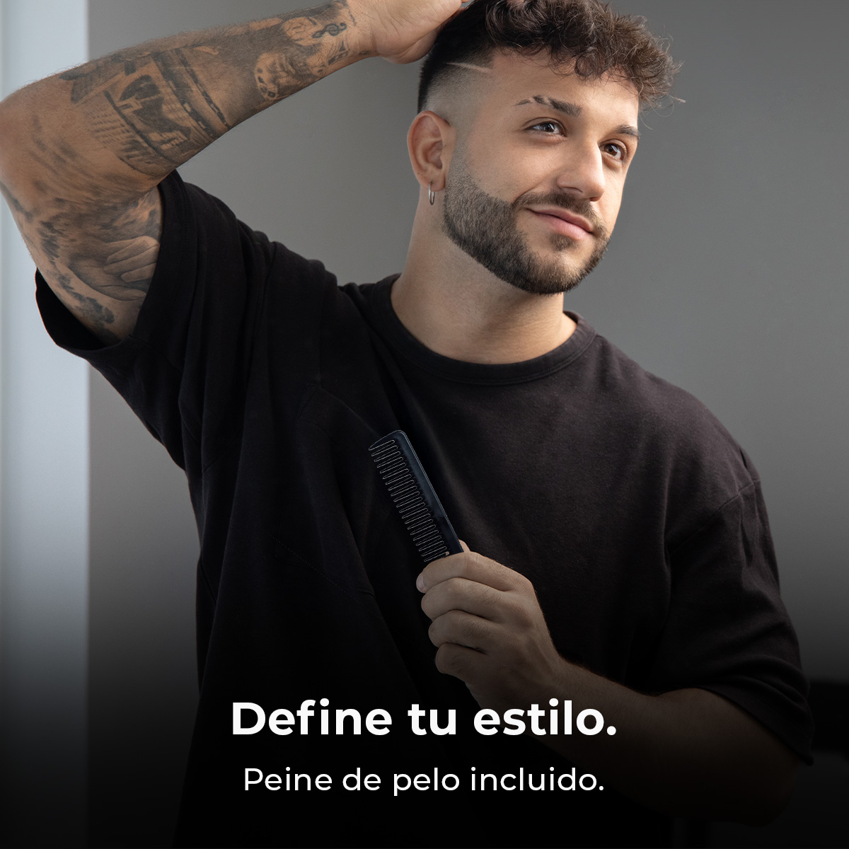 Hombre con tatuajes y barba sostiene un peine contra un fondo gris. Texto abajo.