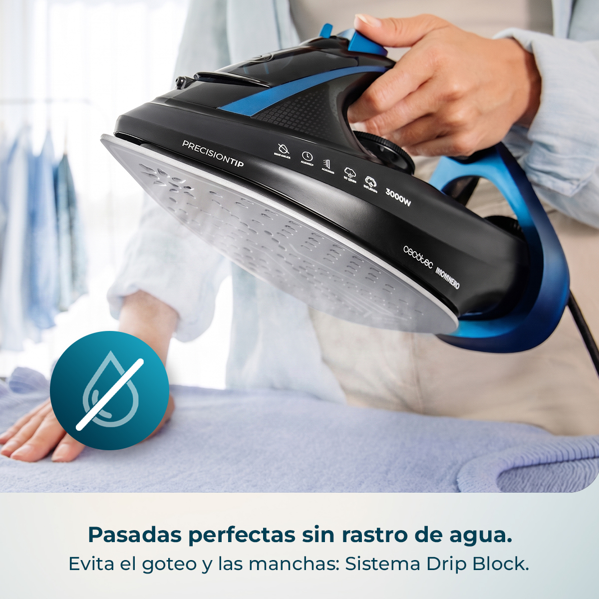 Una persona plancha con una plancha de vapor negra y azul sobre un paño azul.