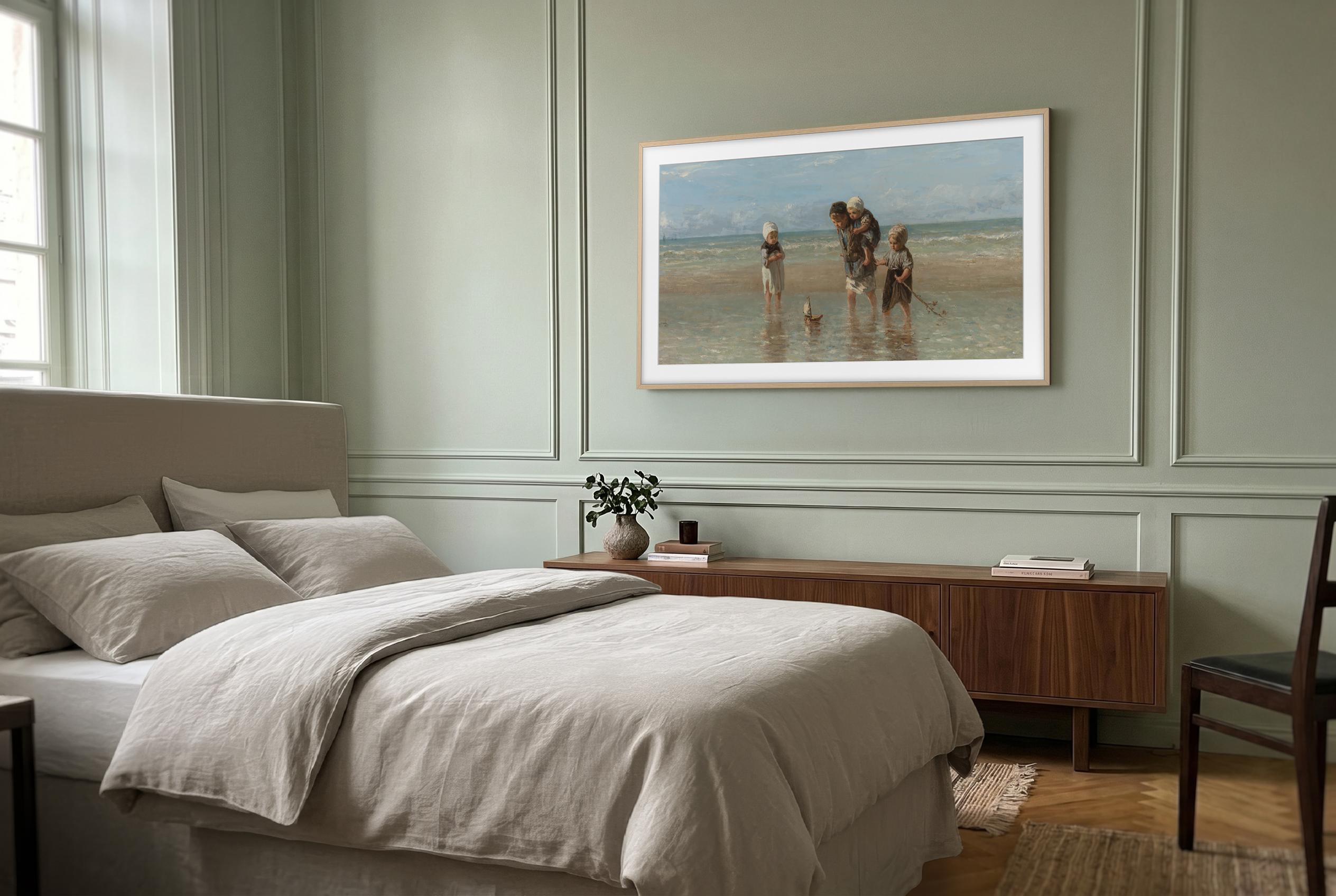 Ein ruhiges Schlafzimmer mit grauem Bett, Holzschrank, Stuhl und Strandgemälde an grüner Wand.