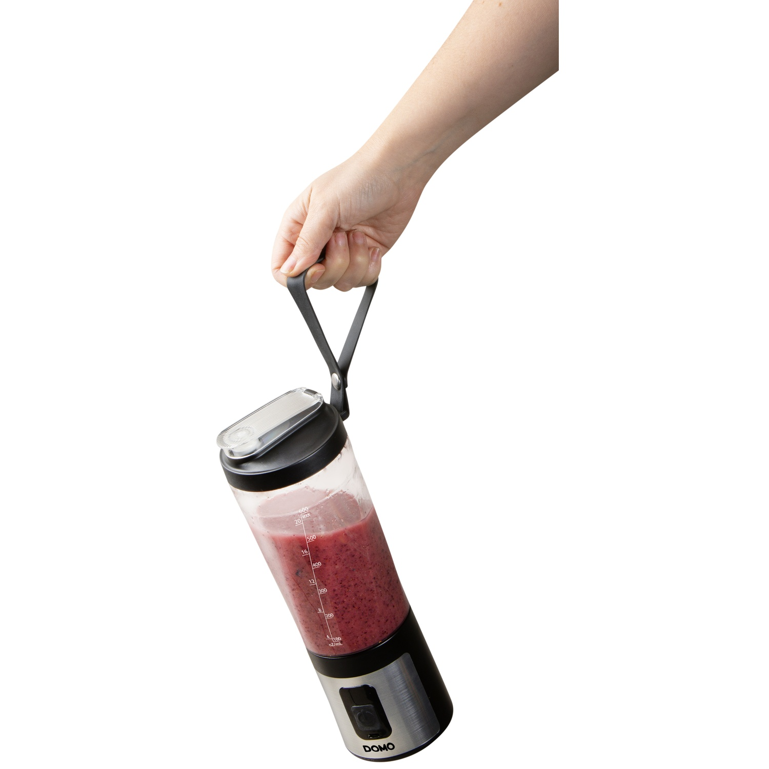 Une main tient une bouteille portable noire et argentée remplie de smoothie rouge.