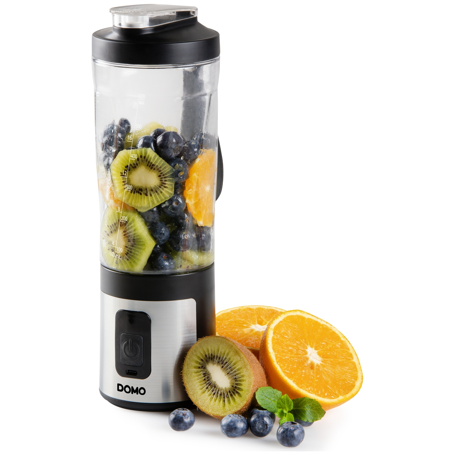 Un blender rempli de kiwi, de myrtilles et d'oranges se trouve à côté de fruits frais.
