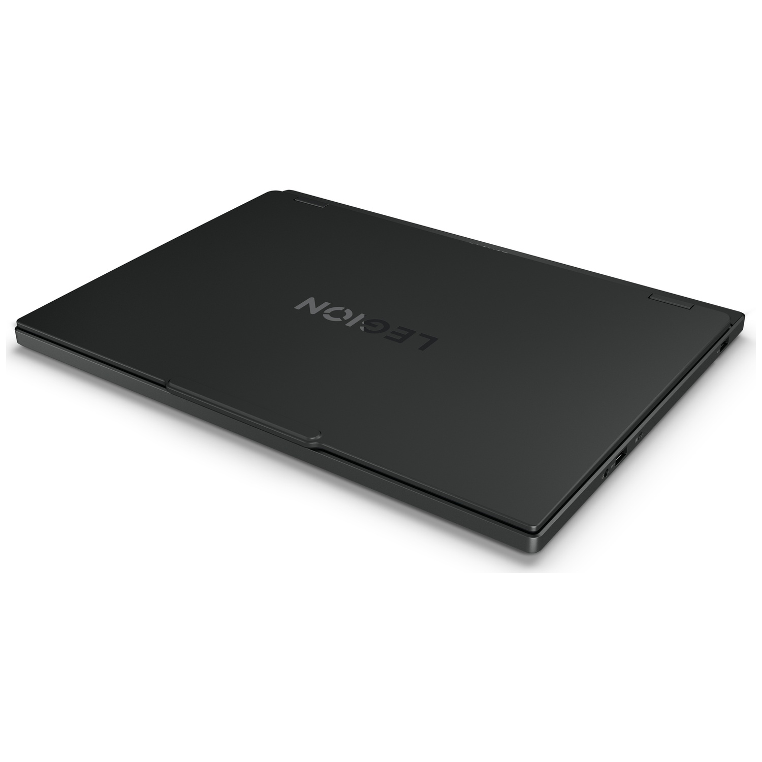 Un ordinateur portable Lenovo Legion noir fermé repose sur une surface blanche avec le logo visible.