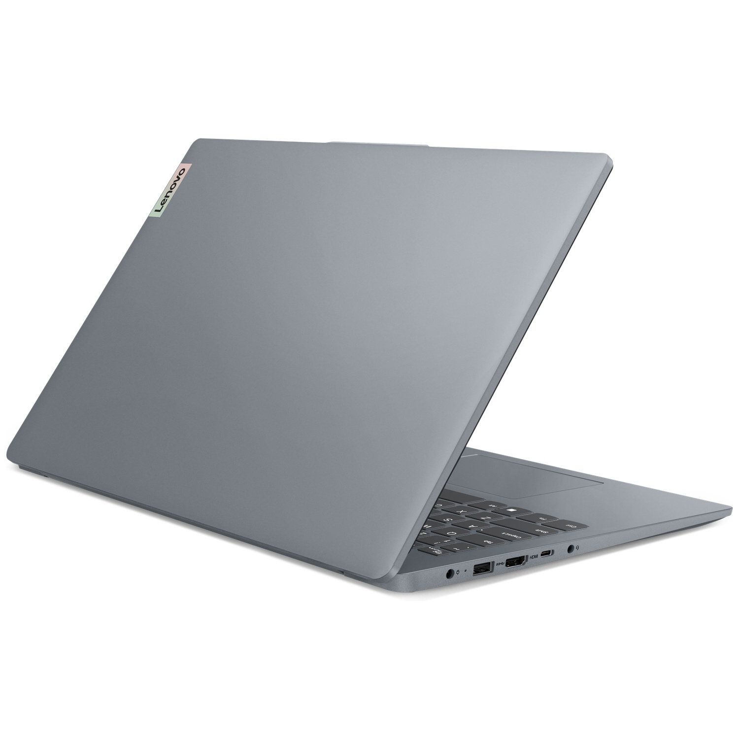 Un ordinateur portable Lenovo gris repose sur une surface blanche, montrant son clavier et ses ports latéraux.