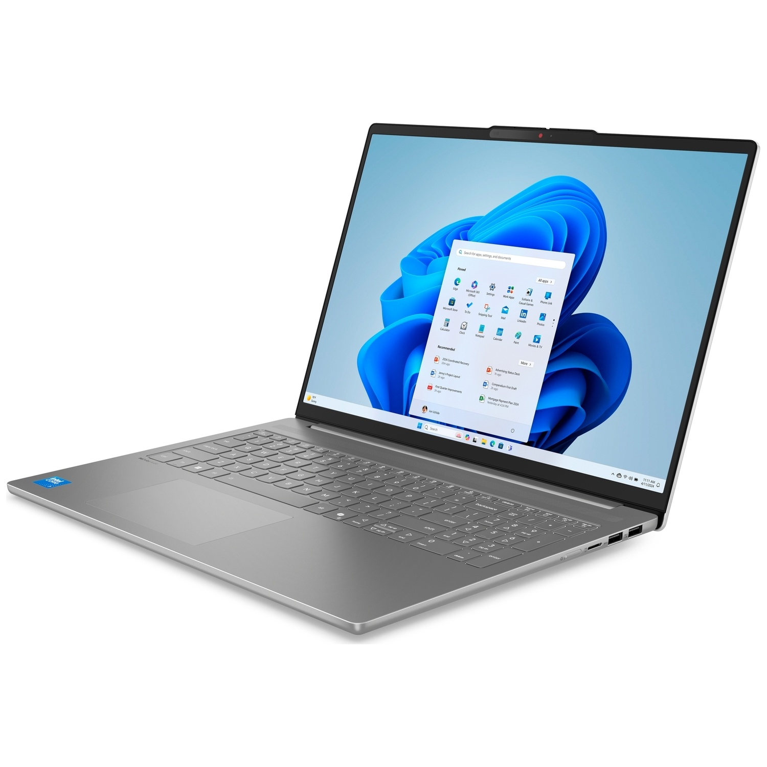 Un ordinateur portable argenté sur une surface blanche affiche le bureau Windows 11.
