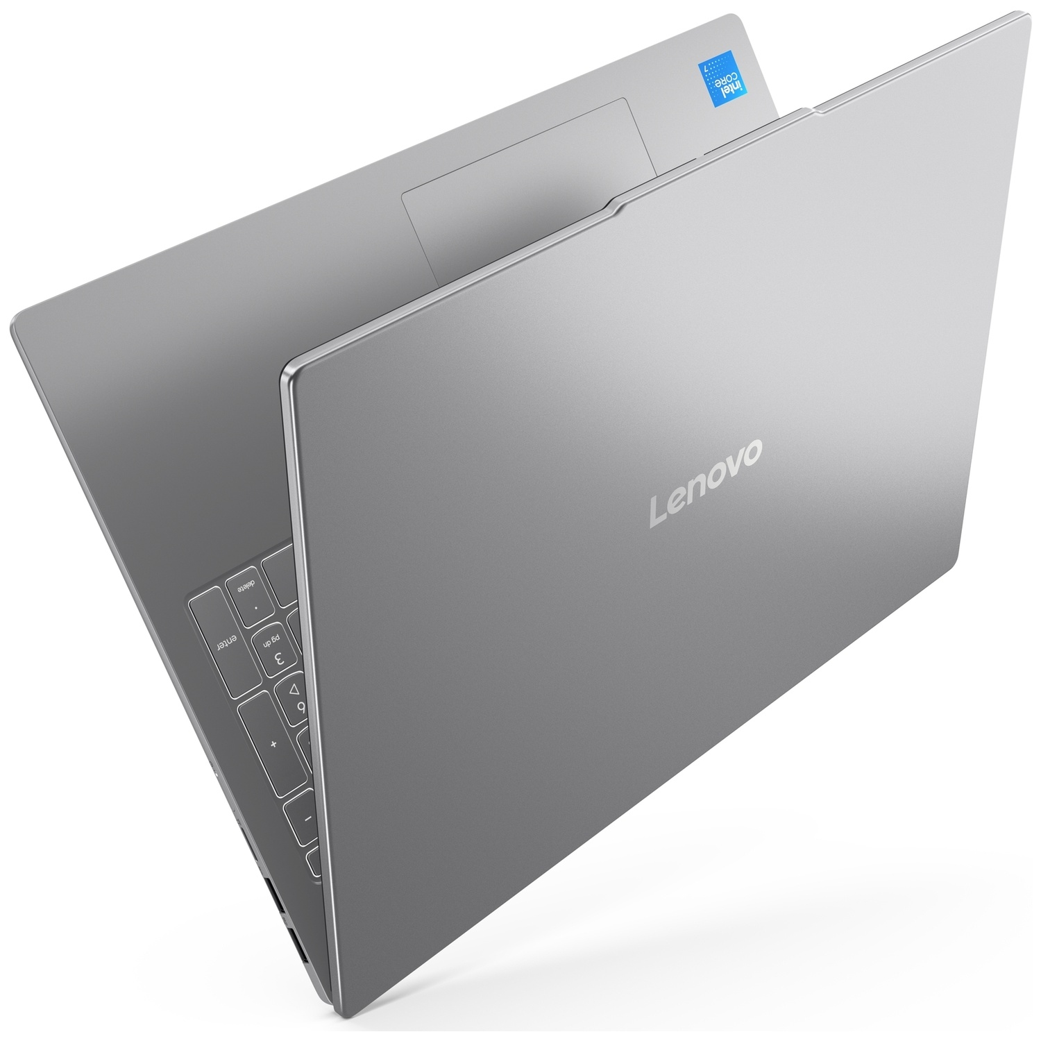Un ordinateur portable Lenovo argenté est partiellement ouvert, montrant le clavier et l'écran fermé sur fond blanc.