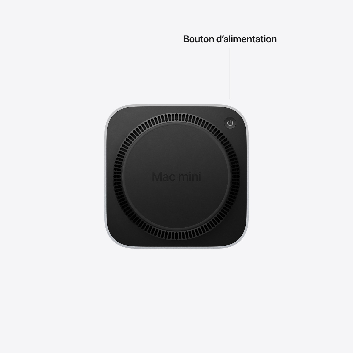 Vue du dessous d'un Mac mini mettant en valeur le bouton d'alimentation avec une étiquette.