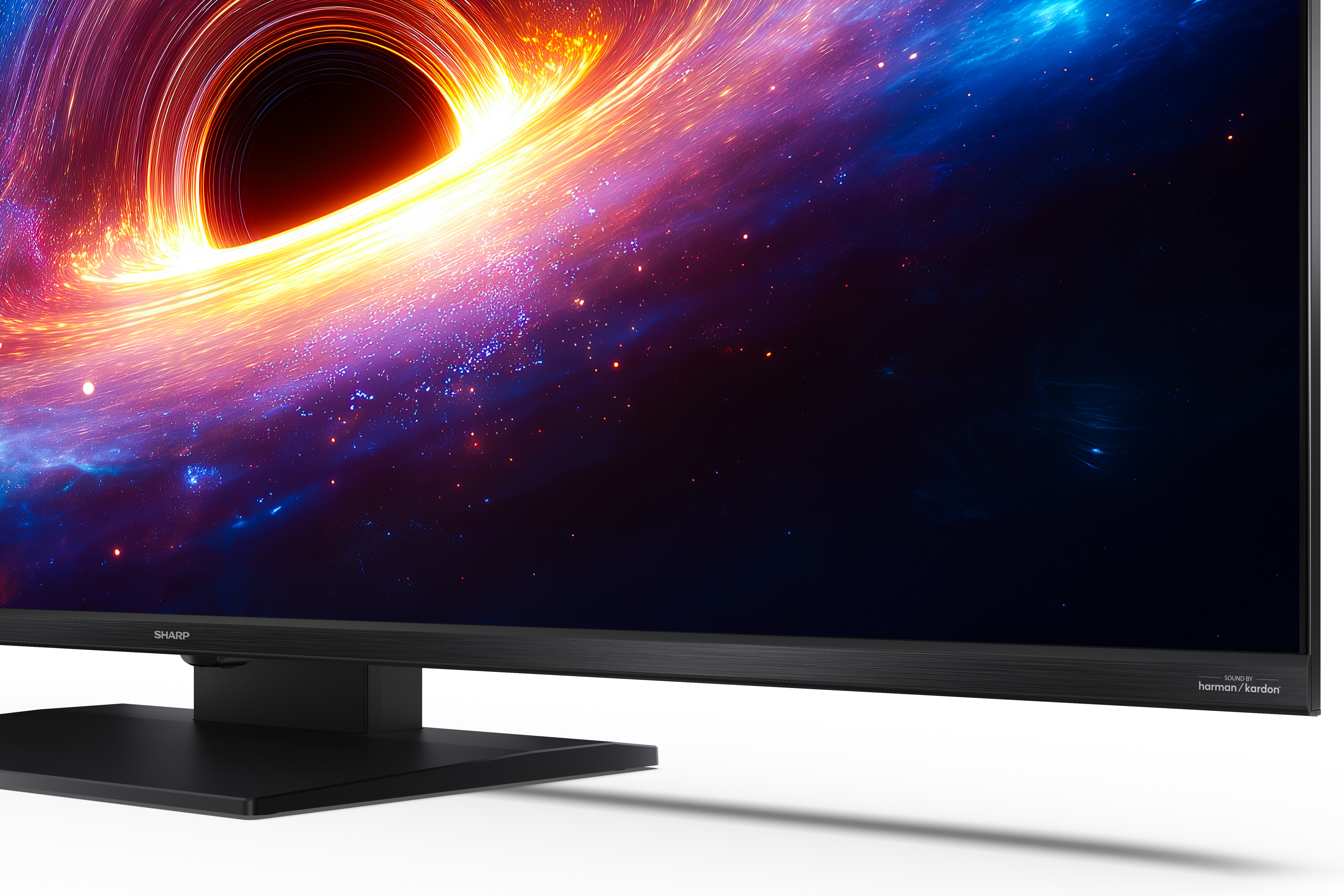 Telewizor Sharp wyświetla żywą scenę kosmiczną z świecącą czarną dziurą i kolorowym pyłem.
