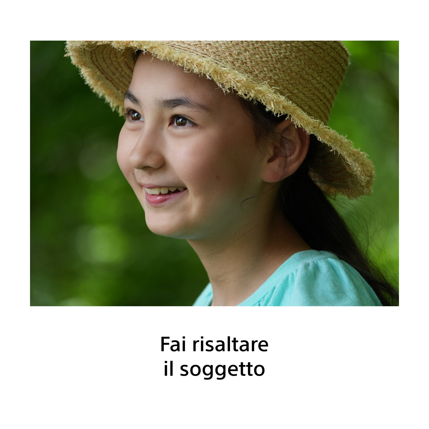 Una ragazza sorridente con cappello di paglia e maglietta azzurra su sfondo verde.