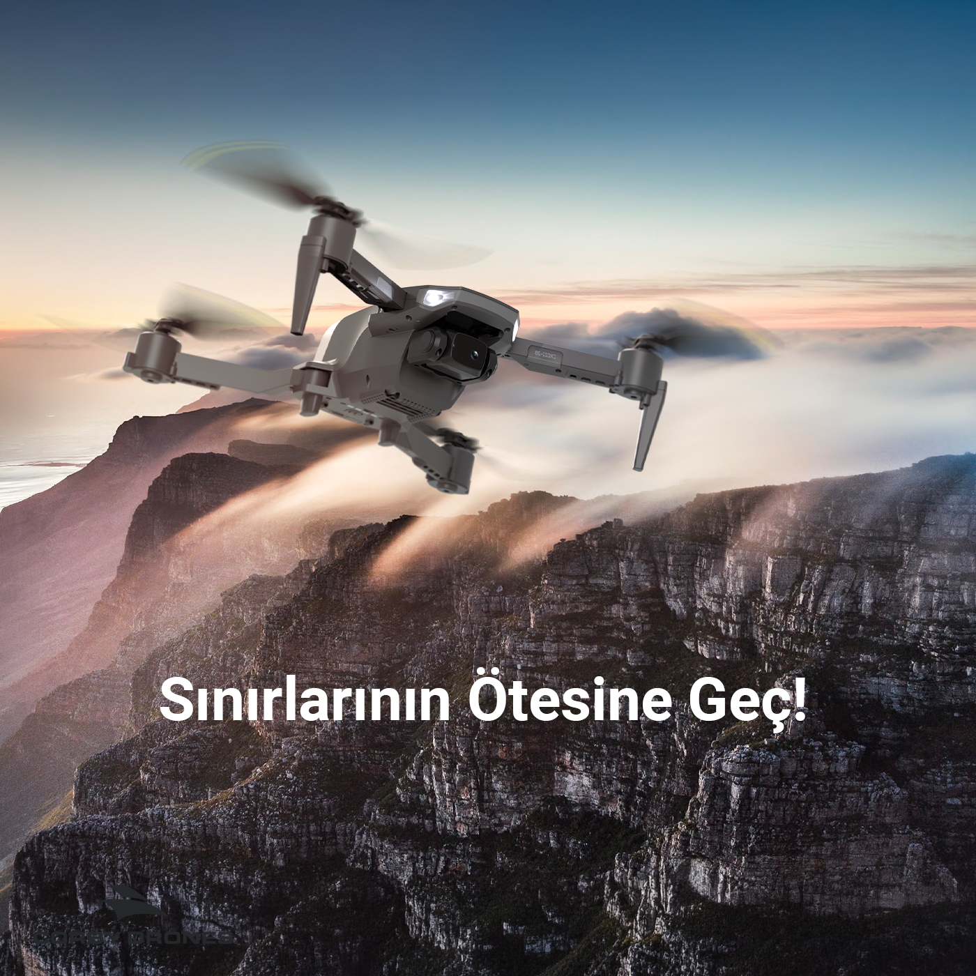 Gün batımında kayalık dağların üzerinde uçan bir drone ve üzerinde metin.