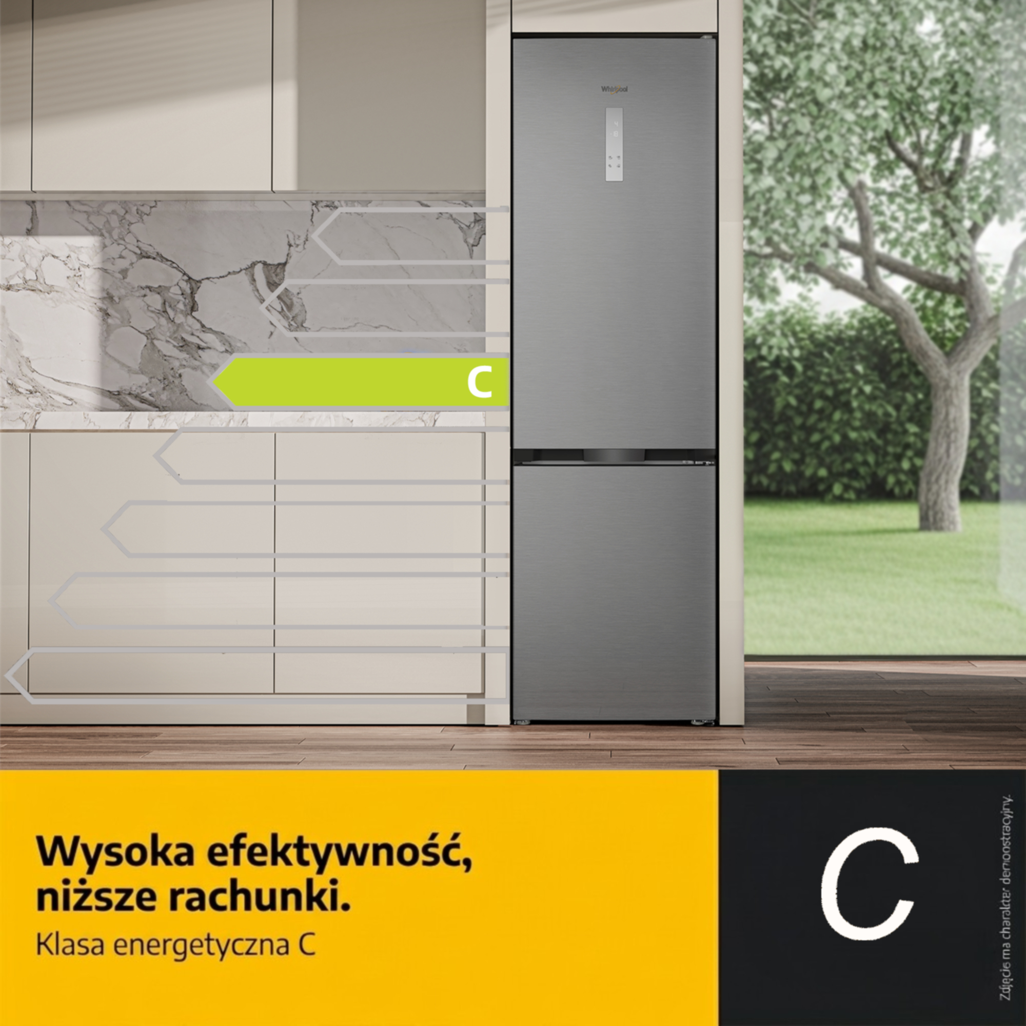 Szara lodówka w kuchni z klasą energetyczną C, podświetlona zieloną strzałką.