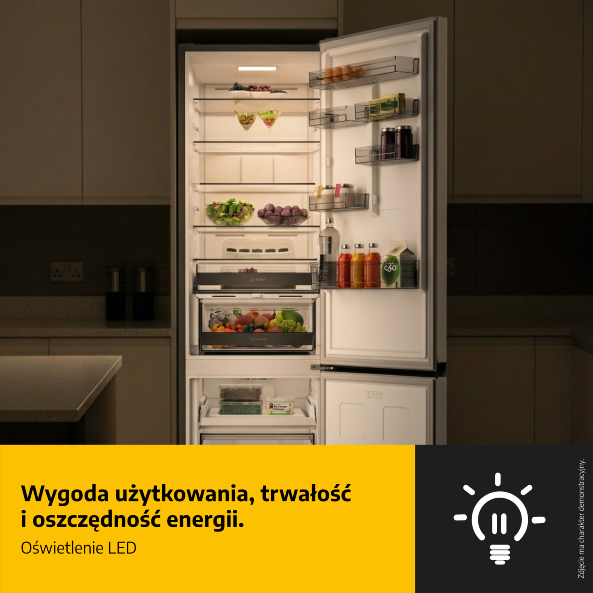 Otwarta lodówka z oświetlonymi półkami i jedzeniem w kuchni.
