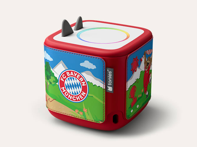 Rote Toniebox mit FC Bayern München Motiv, blauer Landschaft und kleinen grauen Ohren oben.