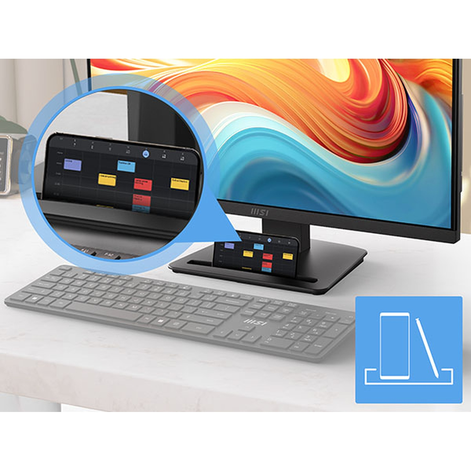 Un monitor per computer con base dotata di supporto integrato per smartphone e una tastiera grigia.