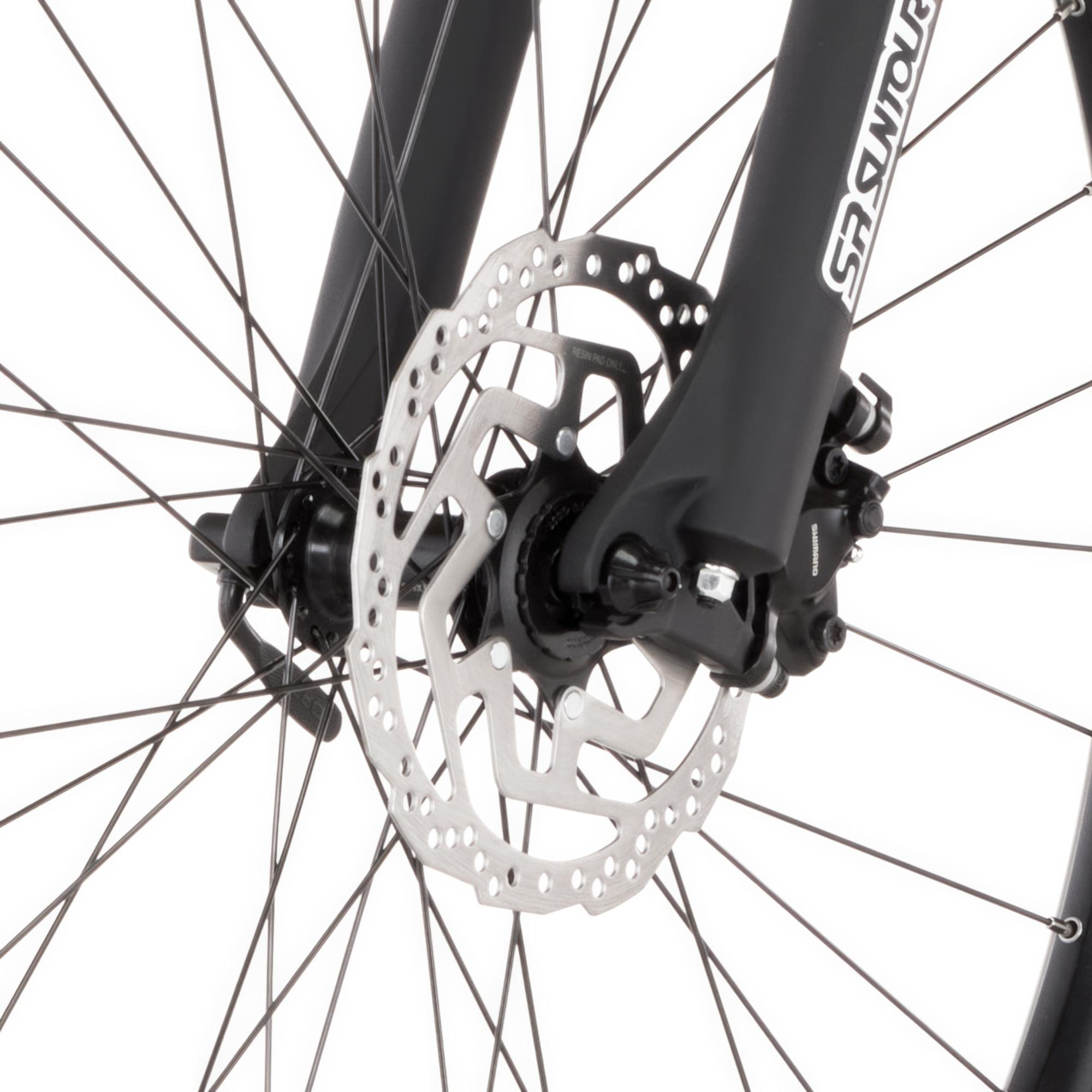 Nahaufnahme einer Fahrrad-Scheibenbremse mit silbernem Rotor, schwarzen Gabeln und zahlreichen Speichen.
