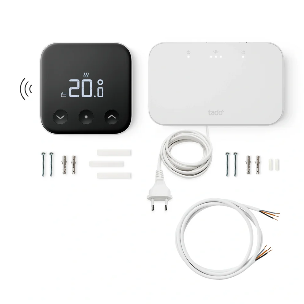 Control de calefacción Tado con termostato digital, receptor blanco, cables y kit de montaje sobre fondo blanco.