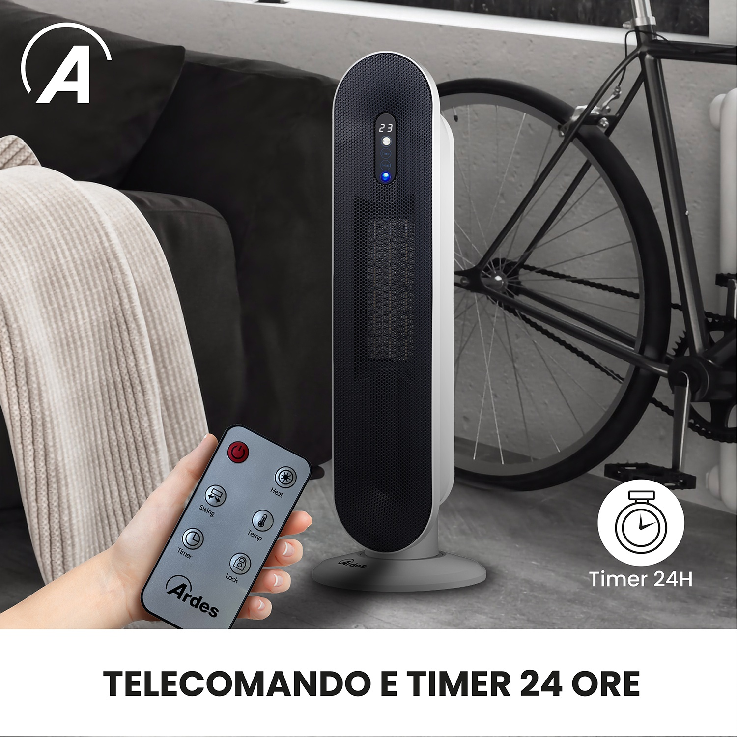 Una mano regge un telecomando davanti a una stufa a torre in una stanza con divano e bicicletta.