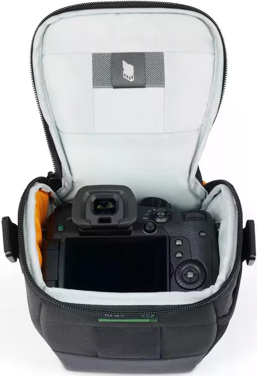 Una fotocamera nera all'interno di una borsa imbottita aperta con fodera bianca.