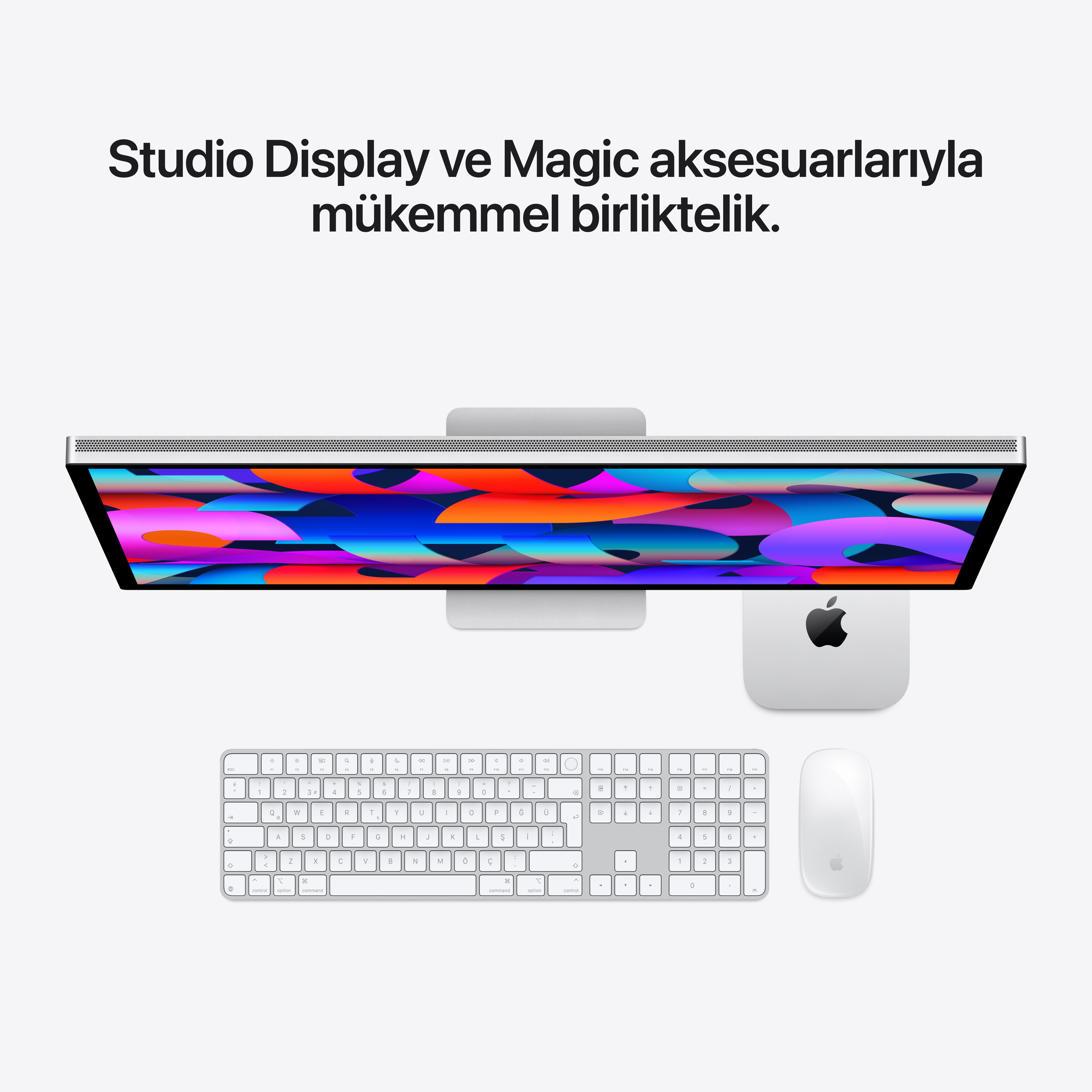 Açık renkli arka planda Apple Studio Display, Mac mini, Magic Keyboard ve Magic Mouse'un üstten görünümü.