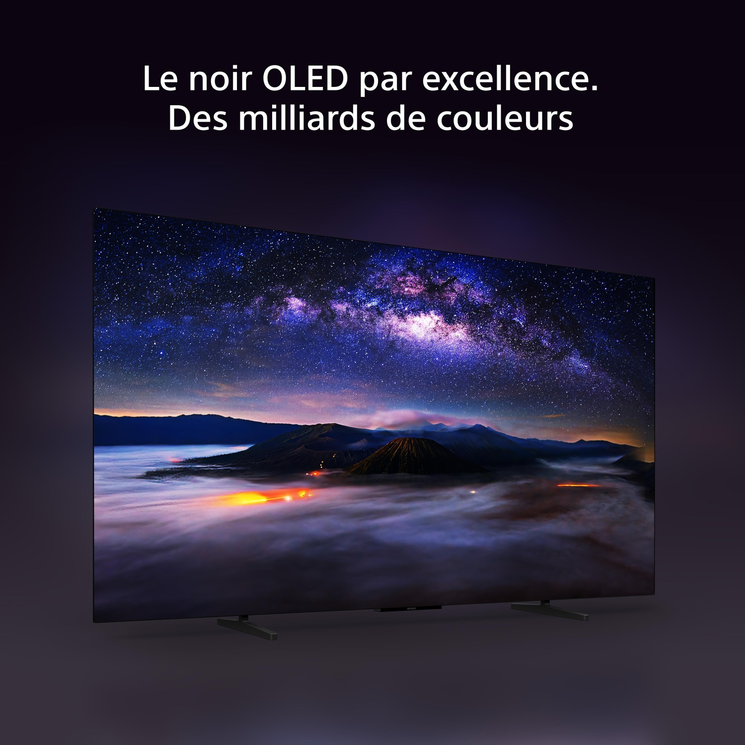 Téléviseur OLED affichant un ciel nocturne coloré et un paysage montagneux sur un fond sombre.