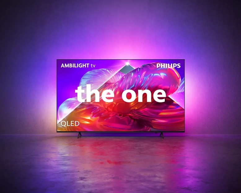 Telewizor Philips Ambilight QLED wyświetla abstrakcyjne kształty, rzucając kolorową poświatę na ścianę i podłogę.