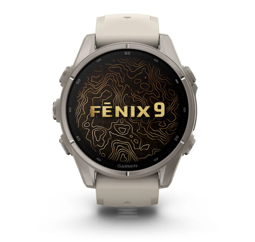 Un reloj inteligente Garmin Fenix 9 gris con correa beige muestra una esfera de mapa topográfico.
