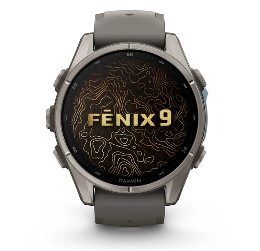 Un reloj inteligente Garmin Fenix 9 gris con esfera de mapa topográfico sobre fondo blanco.