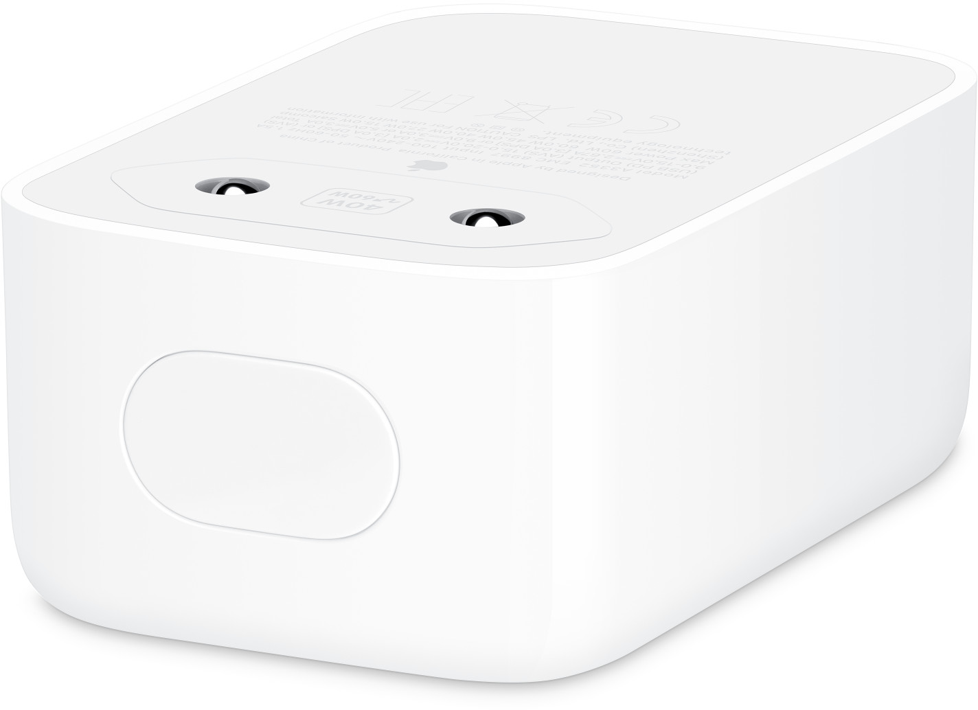 Egy fehér Apple hálózati adapter lekerekített sarkokkal és két villával egy fehér felületen.