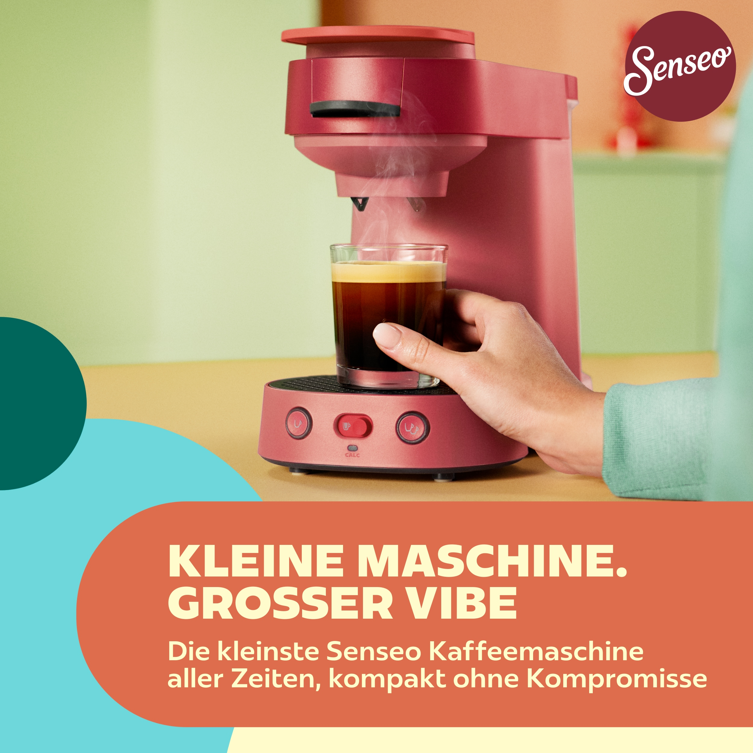 Rote Senseo-Kaffeemaschine braut frischen Kaffee in ein Glas, gehalten von einer Hand.