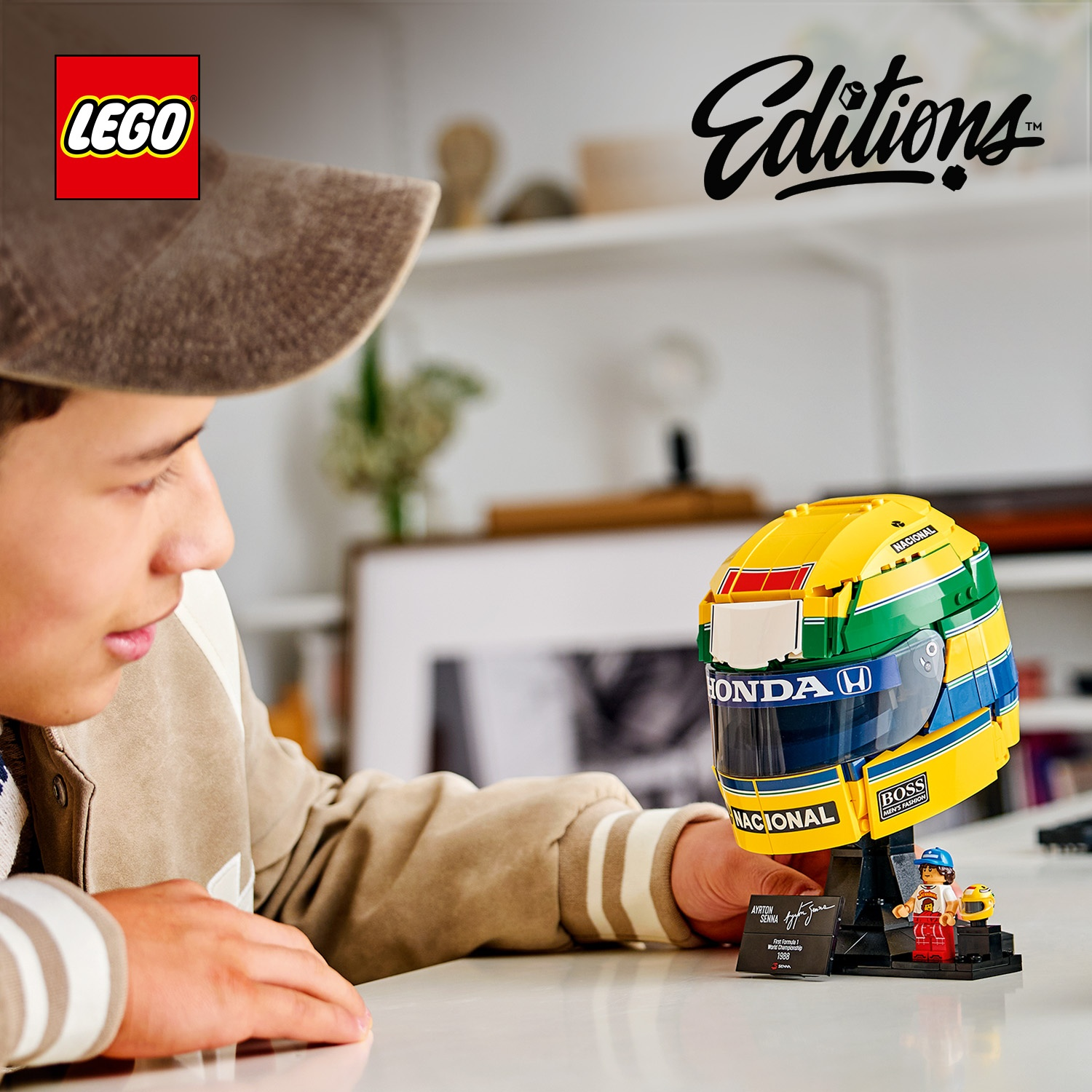 Un ragazzo guarda un modello di casco da corsa LEGO Ayrton Senna con minifigura.
