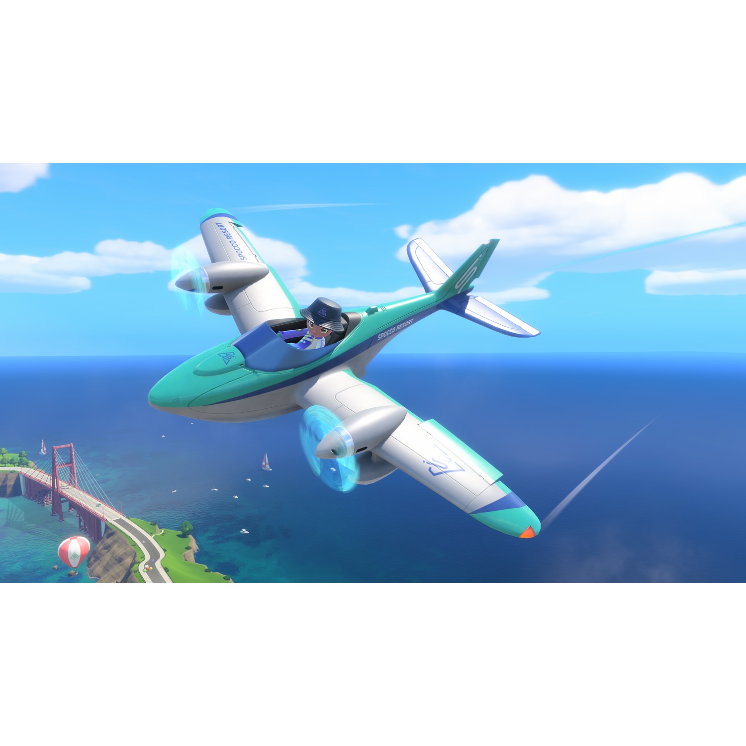A green and white airplane flies over the blue sea with a red bridge and sailboats in the background.