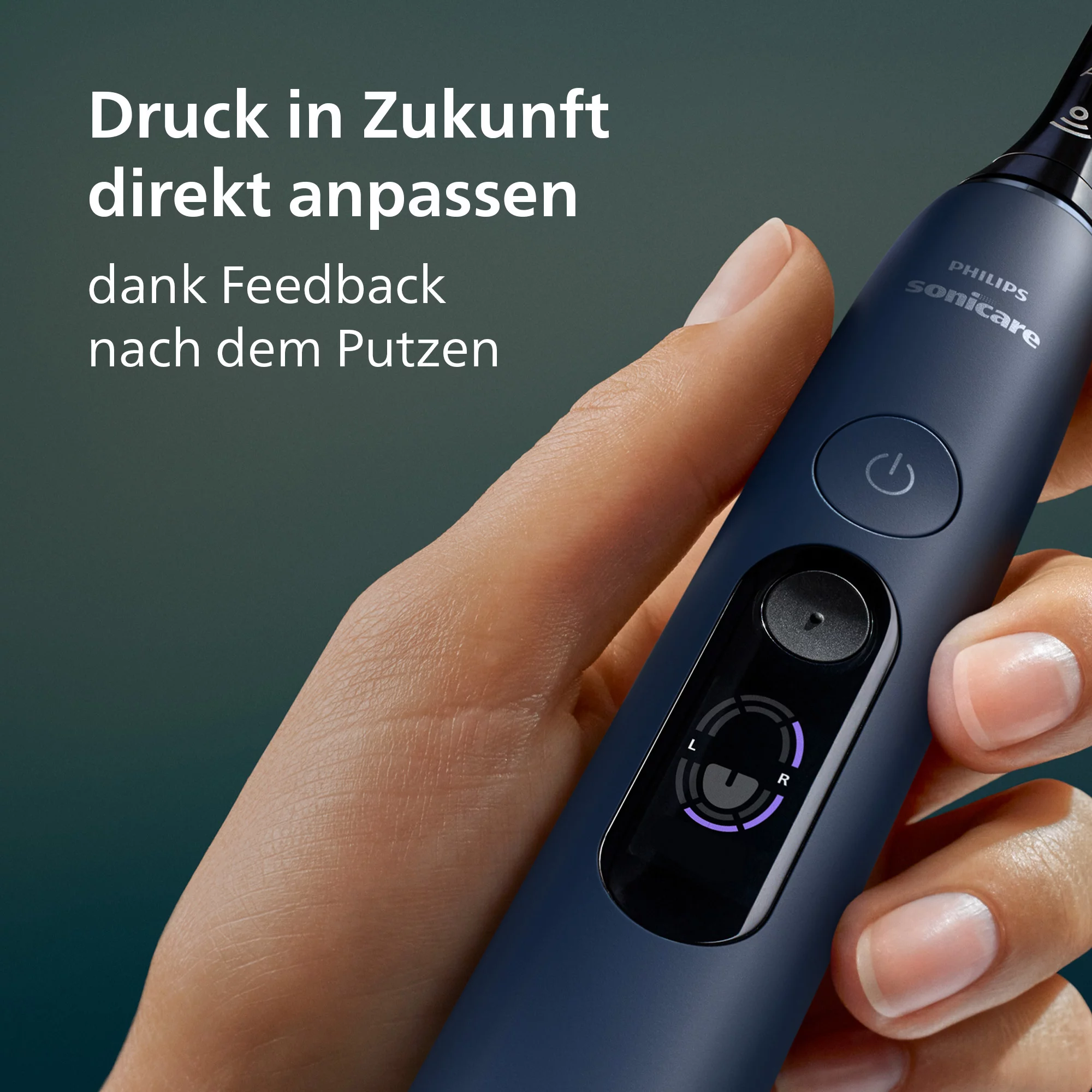 Egy kéz sötétkék Philips Sonicare elektromos fogkefét tart világító kijelzővel.