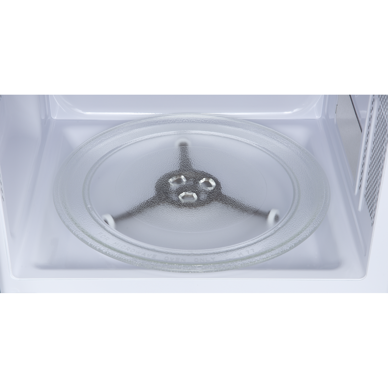 A glass turntable inside the empty white interior of a microwave oven.