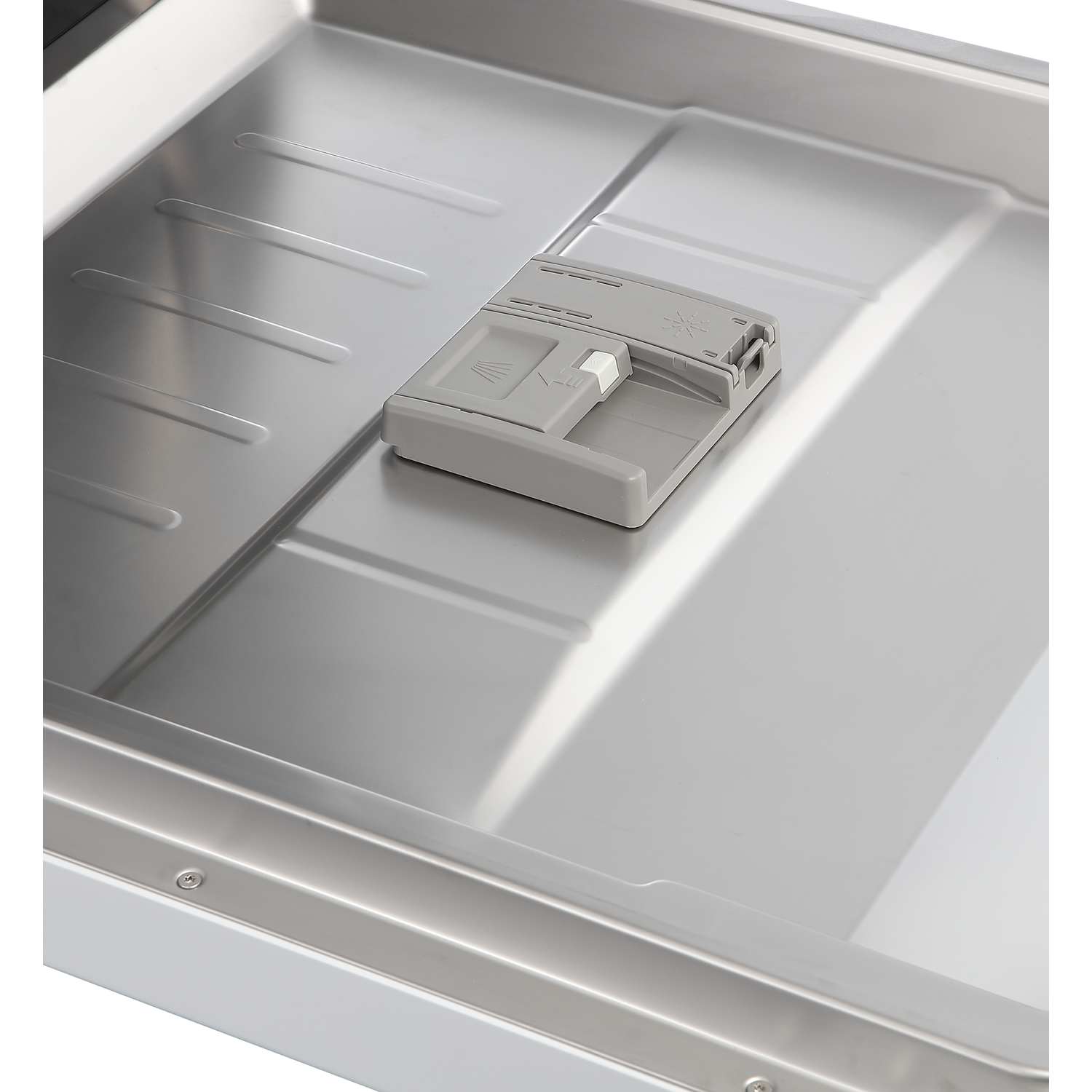 L'intérieur d'un lave-vaisselle en acier inoxydable avec un distributeur de détergent gris fermé sur la porte intérieure.