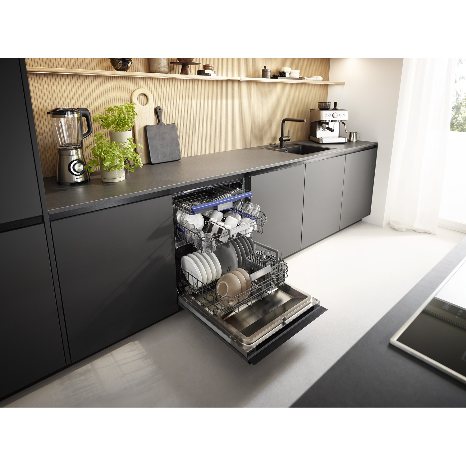 Un lave-vaisselle noir est ouvert, rempli de vaisselle et de verres, dans une cuisine moderne.