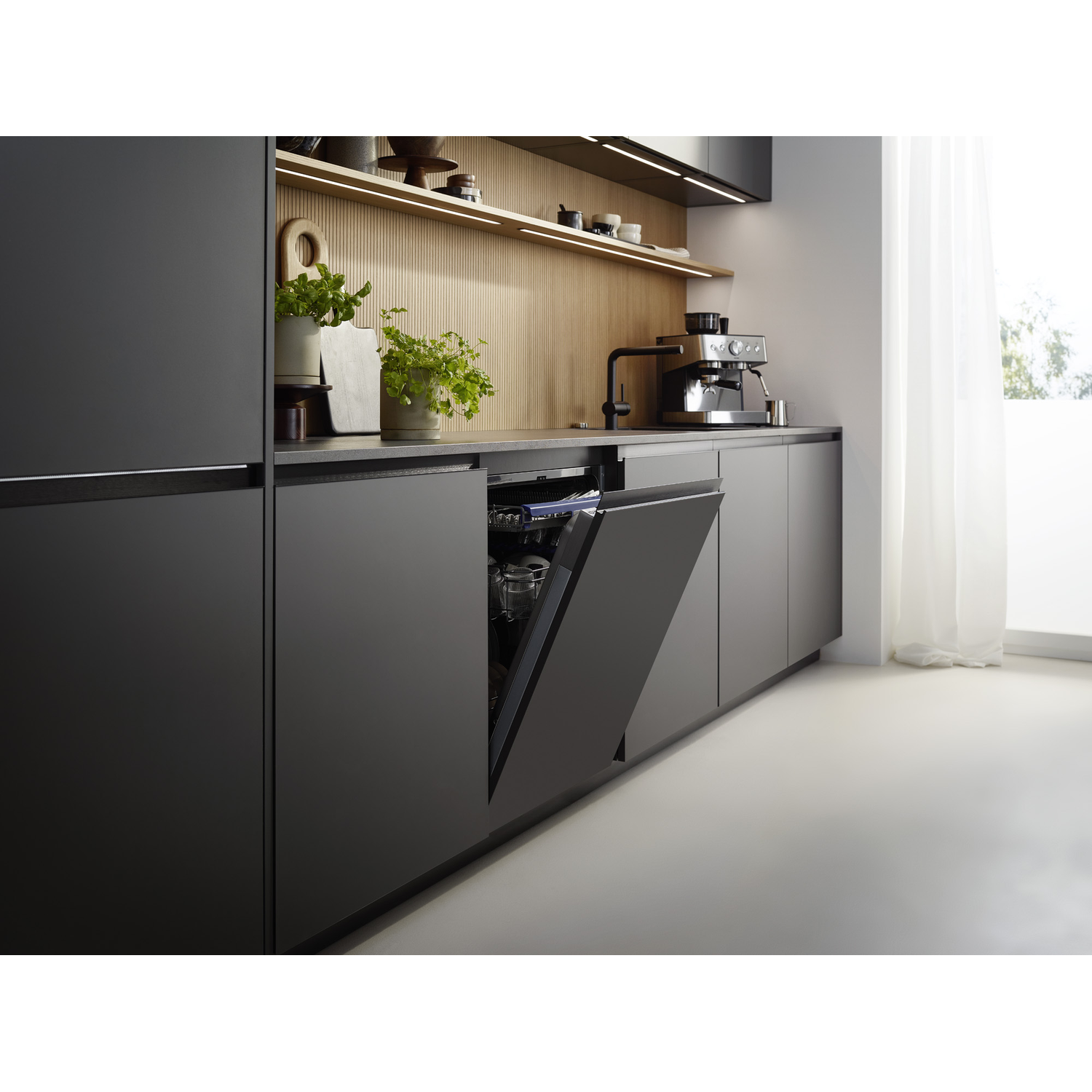 Cuisine sombre moderne avec crédence en bois, lave-vaisselle ouvert et cafetière sur le comptoir.