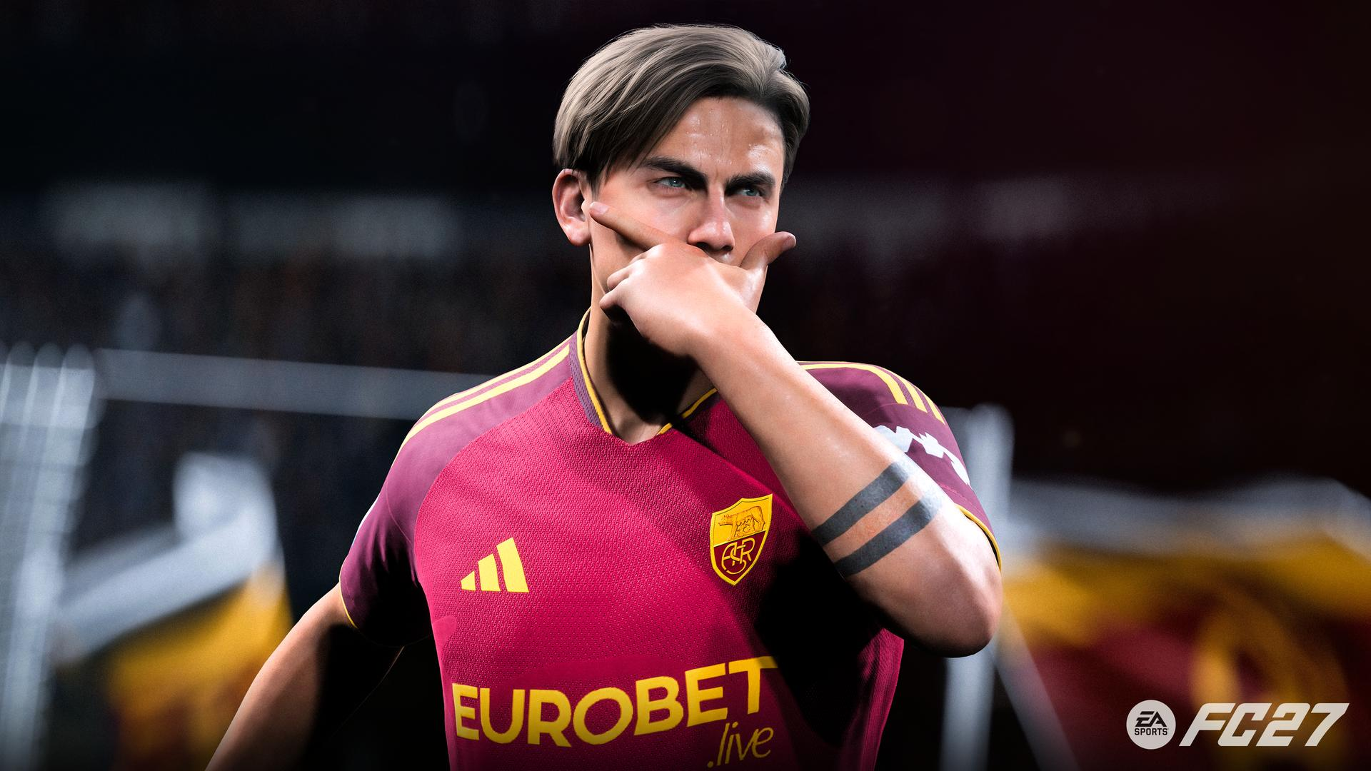 Ein Fußballspieler im dunkelroten AS Rom Trikot feiert mit der Geste vor dem Mund.
