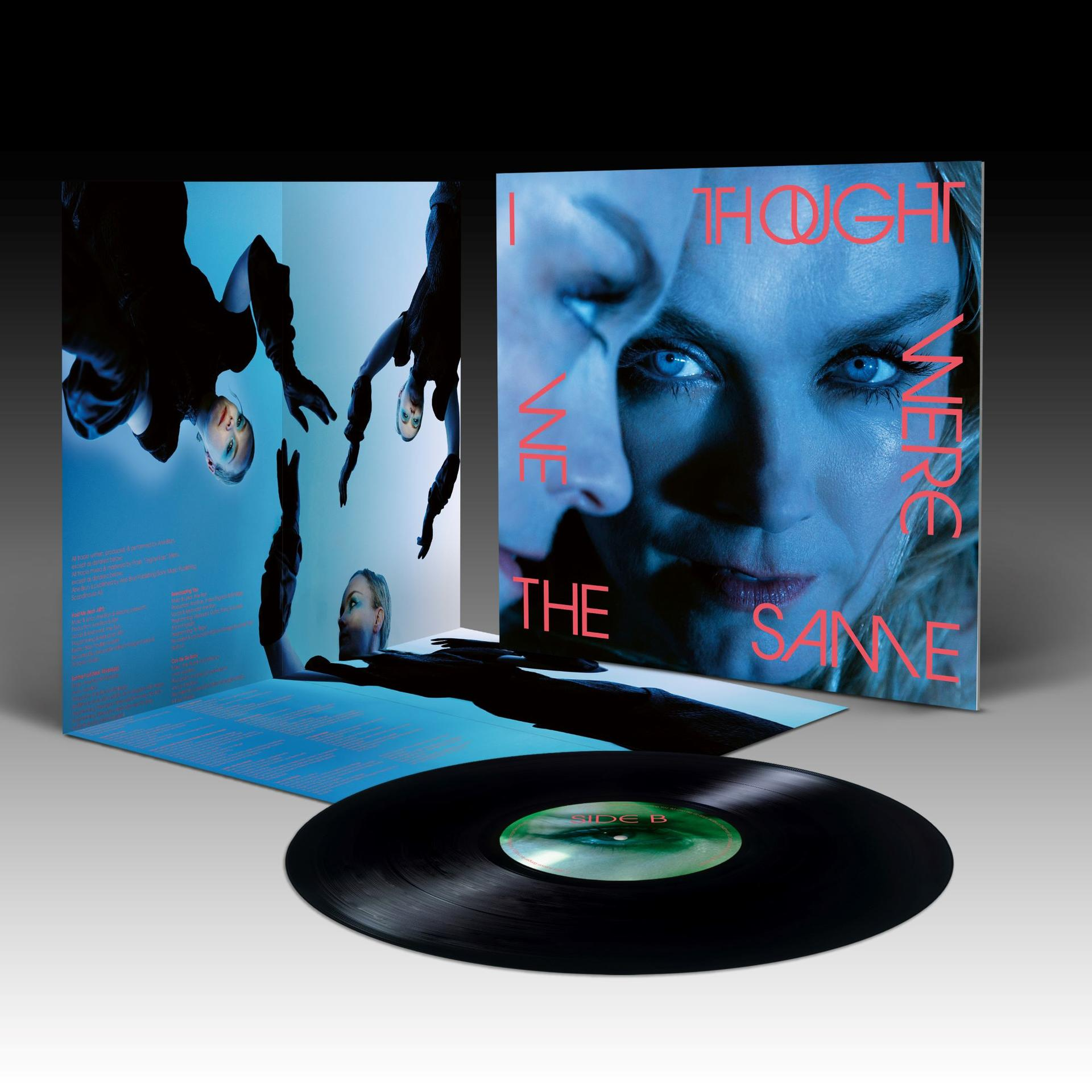 Vinyl-Schallplatte mit blauem Albumcover, das Frauenporträts und rote Textgrafiken zeigt.