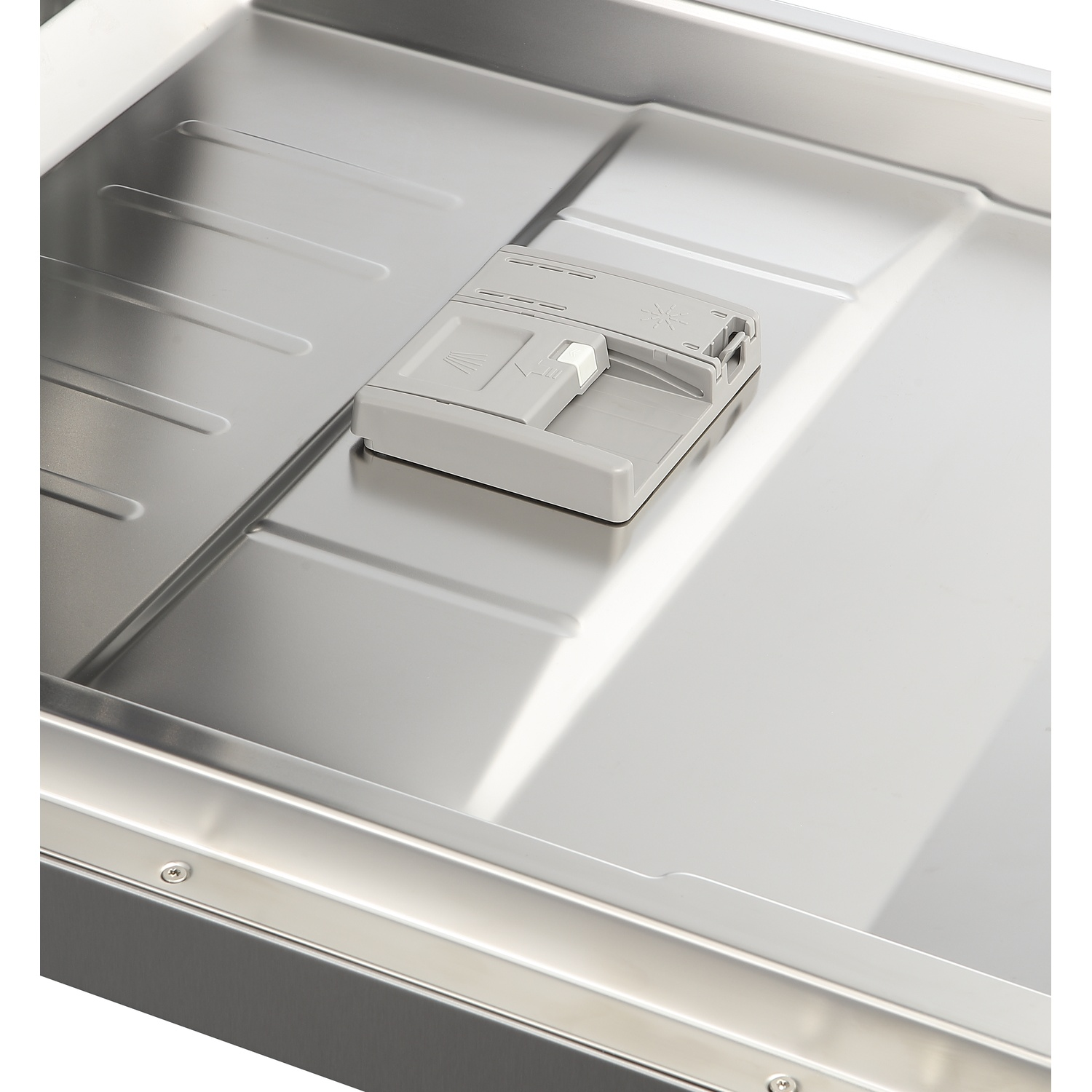The interior of a stainless steel dishwasher with a closed detergent dispenser.