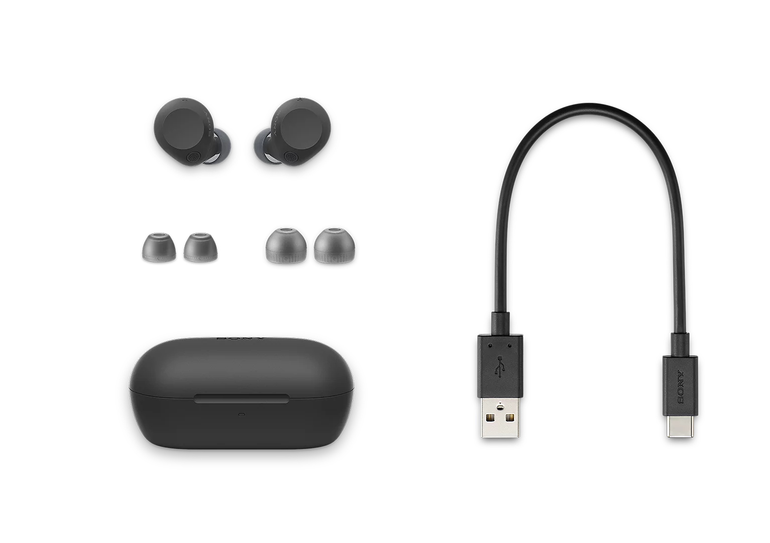 Siyah kablosuz kulak içi kulaklık, şarj kutusu, ekstra kulaklık uçları ve USB kablosu.