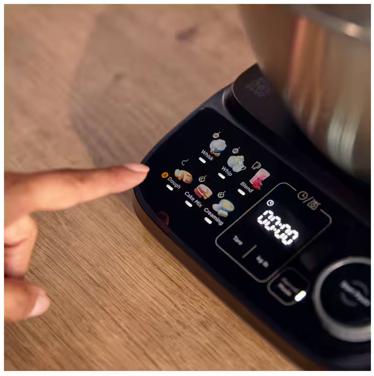 Un dito tocca il pannello di controllo di un elettrodomestico da cucina con icone illuminate.