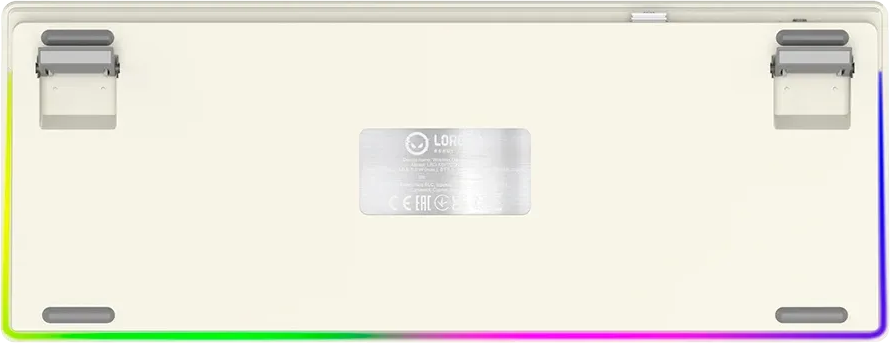 Egy bézs színű billentyűzet alja, két állítható lábbal, középen ezüst címkével és színes RGB háttérvilágítással.