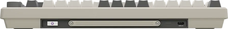 Egy bézs színű billentyűzet oldalsó nézete USB-C porttal és fehér gombokkal.
