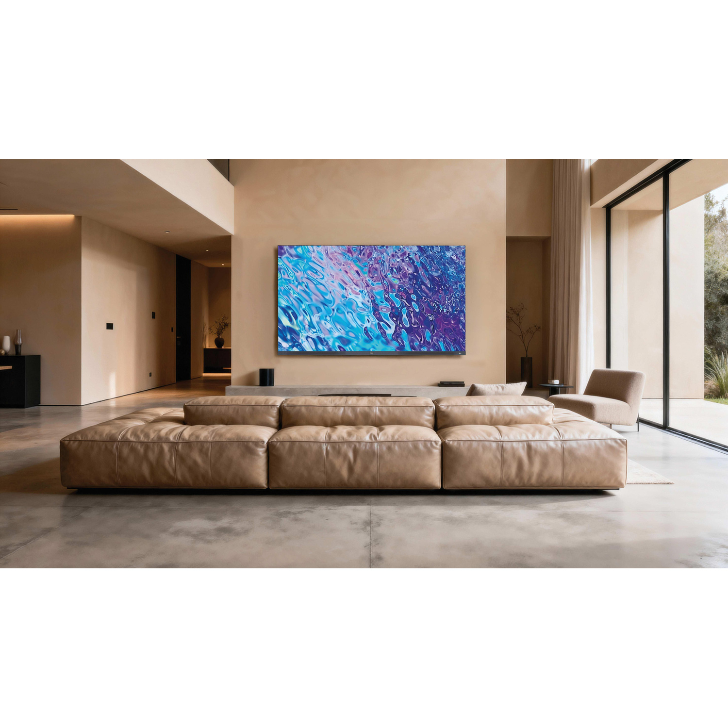 Moderno soggiorno con un grande divano in pelle beige e una TV a parete che mostra un motivo astratto blu.