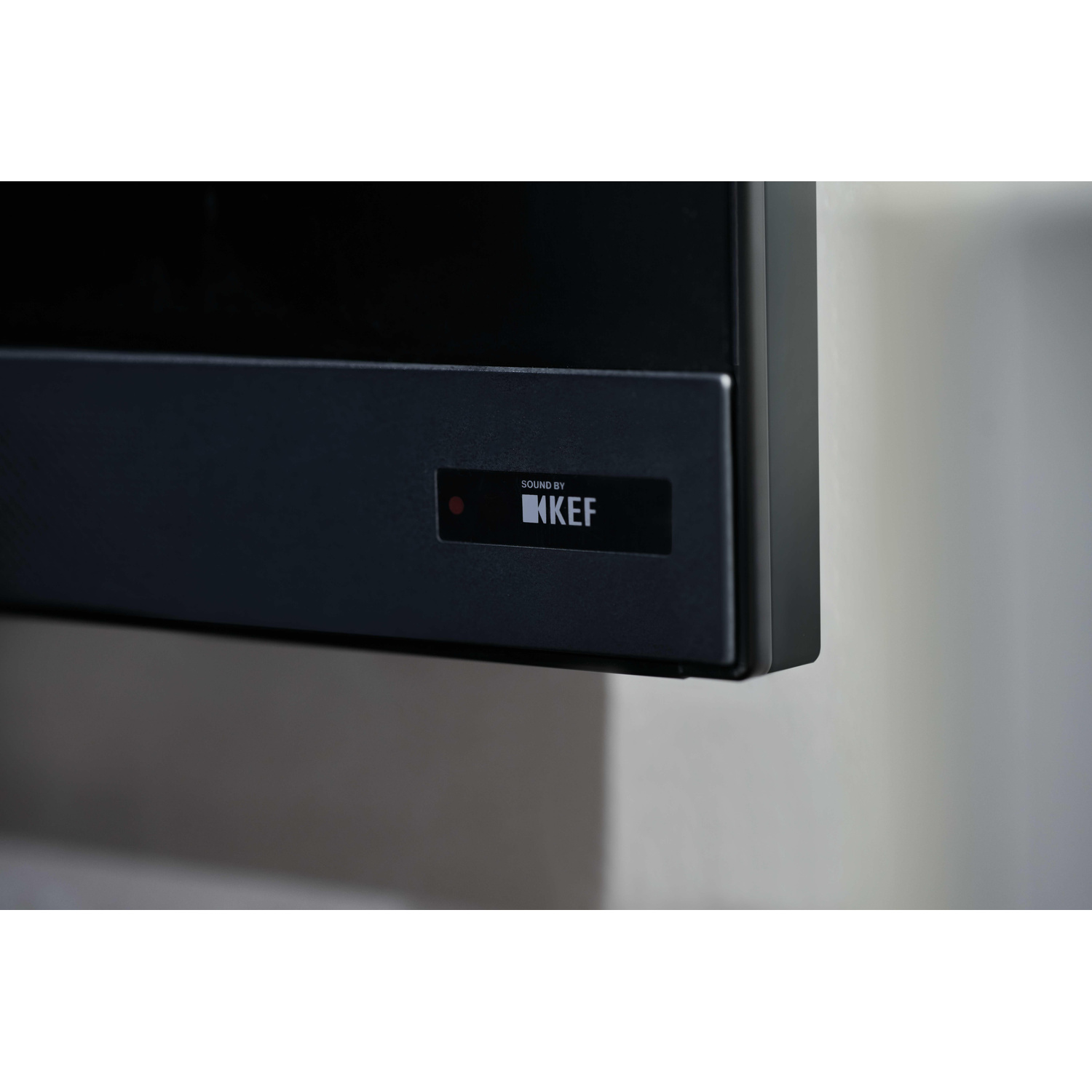 Un dispositivo nero con una luce rossa e la scritta Sound by KEF.