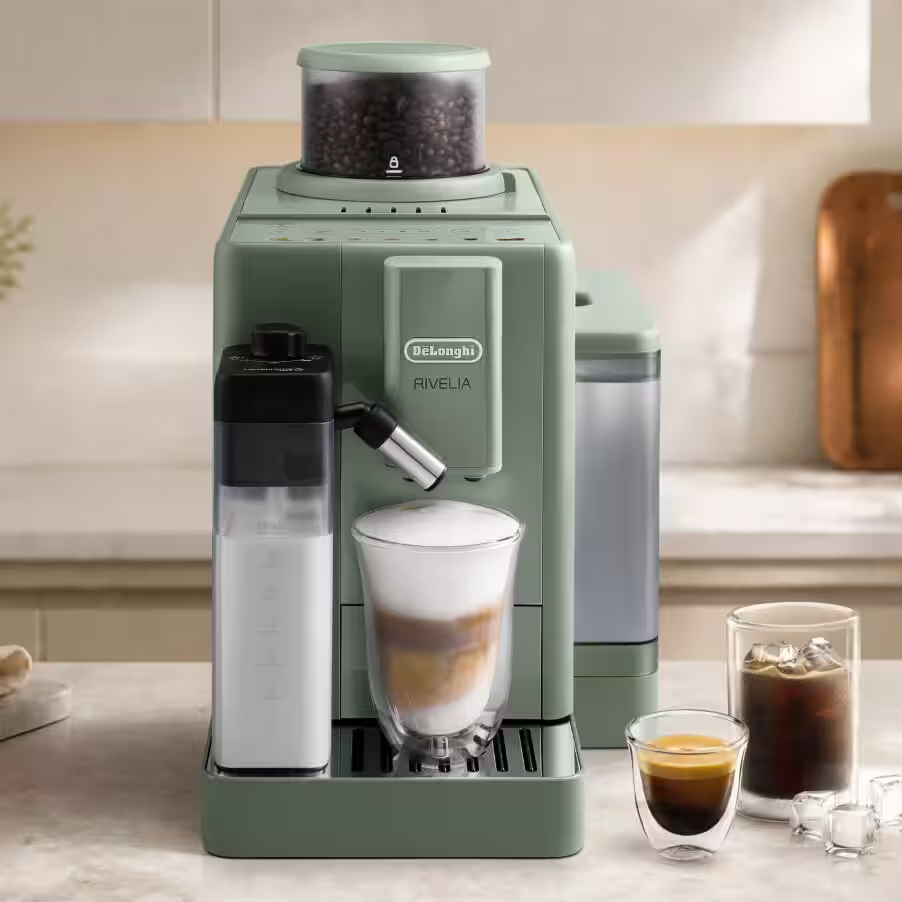 Zöld De'Longhi Rivelia kávéfőző konyhapulton tejkiöntővel és poharakkal.